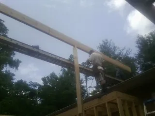 Carpenter setting a ridge beam over a new addition frame — Ice Dam Removal by Roofing Brothers in Santa Rosa