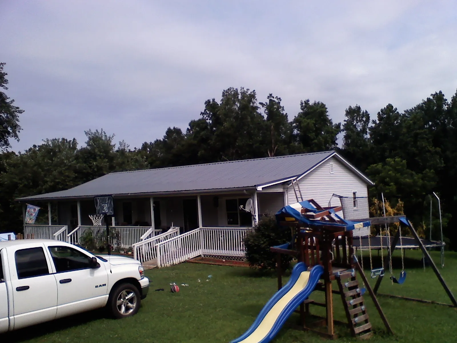 Dark metal roof on a country home with a full length front porch in Santa Rosa