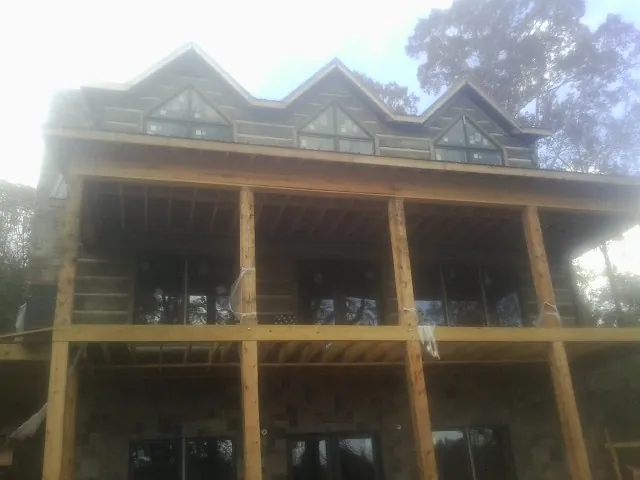 Dormers and porch framing on a large log home under construction — Roof Coating work by our crew in Santa Rosa