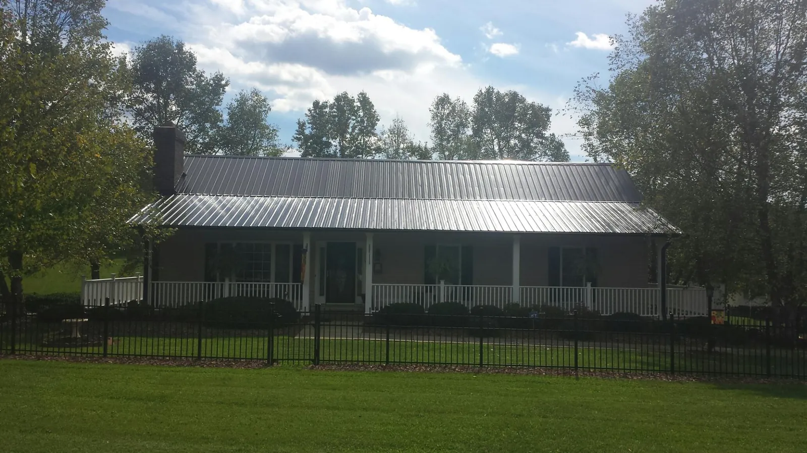 Gray metal roof on a brick ranch with a full width front porch — Gutter Guard Installation work by our crew in Santa Rosa